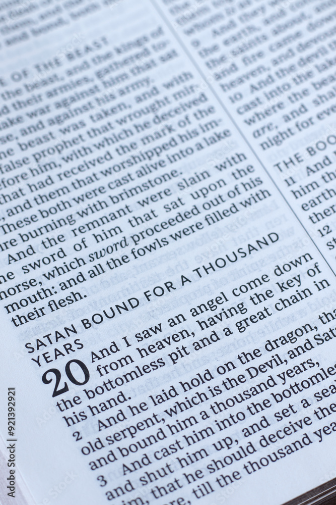 Satan bound for thousand years, biblical verses in open holy bible book. Close-up. Revelation prophecy, Christian biblical concept. Satan bound for thousand years, biblical verses in open holy bible book. Close-up. Revelation prophecy, Christian biblical concept.