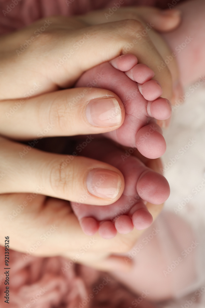 Mother is doing massage on her baby foot. Closeup baby feet in mother hands. Prevention of flat feet, development, muscle tone, dysplasia. Family, love, care, and health concepts. Studio macro. Mother is doing massage on her baby foot. Closeup baby feet in mother hands. Prevention of flat feet, development, muscle tone, dysplasia. Family, love, care, and health concepts. Studio macro.