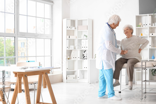 Sick senior woman with back...