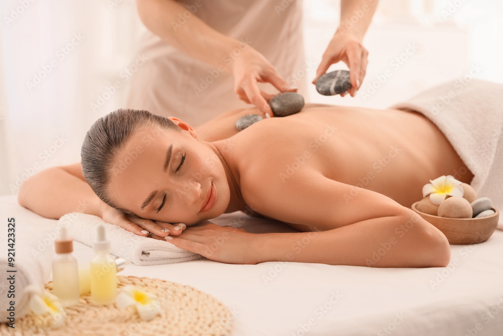 Young woman having massage with hot stones in spa salon Young woman having massage with hot stones in spa salon