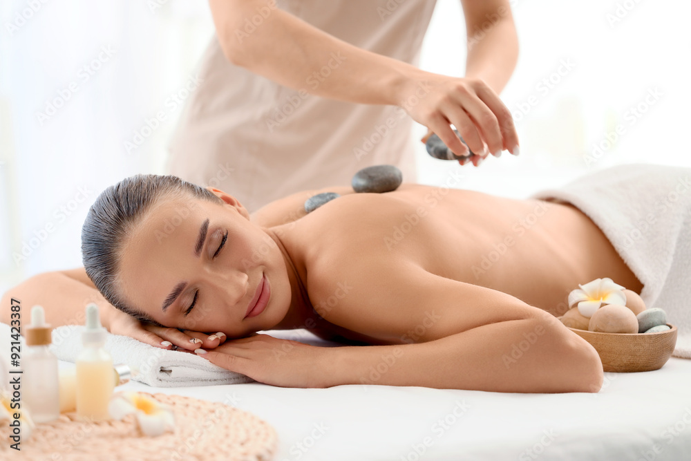 Young woman having massage with hot stones in spa salon Young woman having massage with hot stones in spa salon