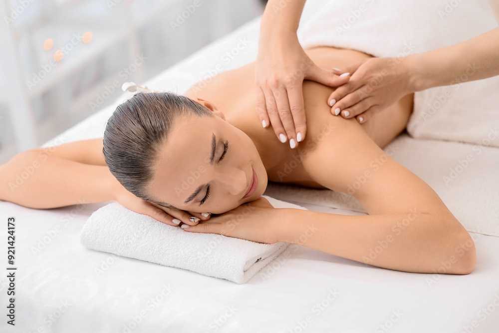 Relaxed young woman getting massage by therapist in spa salon Relaxed young woman getting massage by therapist in spa salon