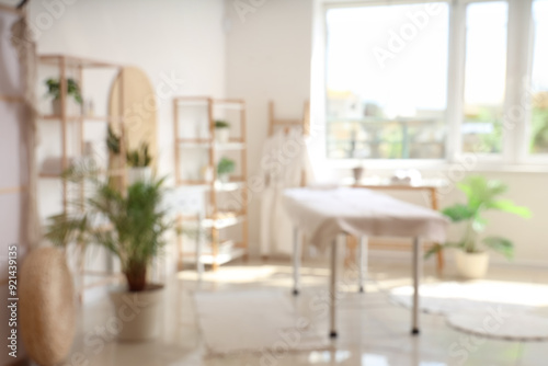 Blurred view of light spa salon with couch, shelving units and folding screen