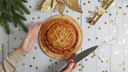 A girl cuts a royal galette on the table..