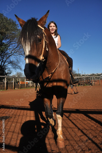 menina vaqueira cavalgando com cavalo marrom  photo