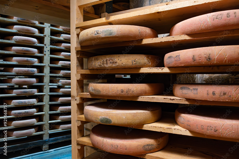 Aging rooms with shelves in cheese caves, central location for aging of wheels, rounds of Comte cheese from four months to several years made from unpasteurised cow milk, Jura, France Aging rooms with shelves in cheese caves, central location for aging of wheels, rounds of Comte cheese from four months to several years made from unpasteurised cow milk, Jura, France