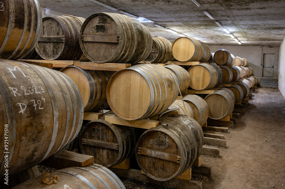 Aging process of cognac spirit in old dark French oak barrels in cellar in distillery house, Cognac white wine region, Charente, Segonzac, Grand Champagne, France Aging process of cognac spirit in old dark French oak barrels in cellar in distillery house, Cognac white wine region, Charente, Segonzac, Grand Champagne, France