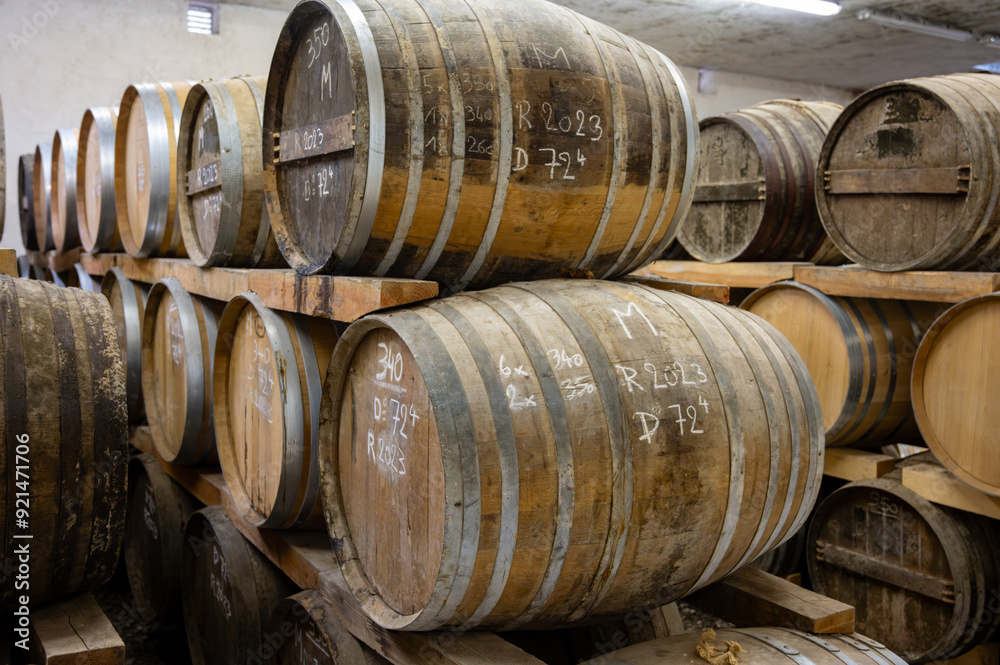 Aging process of cognac spirit in old dark French oak barrels in cellar in distillery house, Cognac white wine region, Charente, Segonzac, Grand Champagne, France Aging process of cognac spirit in old dark French oak barrels in cellar in distillery house, Cognac white wine region, Charente, Segonzac, Grand Champagne, France