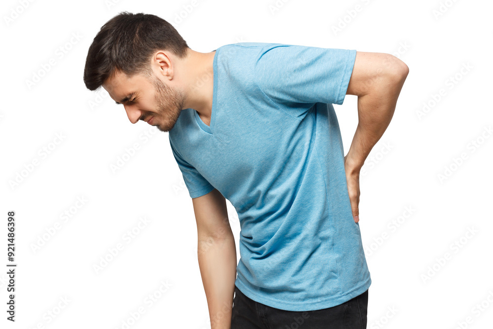 Young unhappy guy in blue t-shirt suffering from severe backache, touching back trying to ease pain in spine