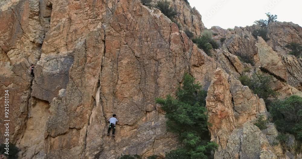 Beautiful low drone shot flying near young rock climber