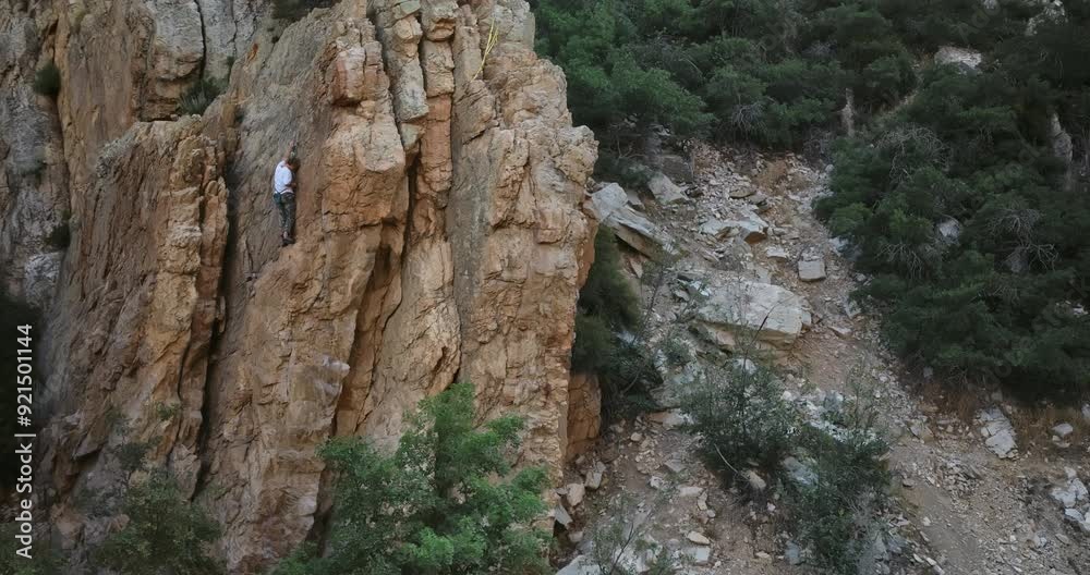 Epic, cinematic fly in on young rock climber on mountain Epic, cinematic fly in on young rock climber on mountain