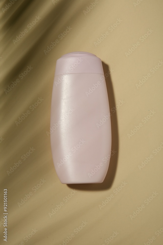 Bottle of shampoo on beige background, top view Bottle of shampoo on beige background, top view