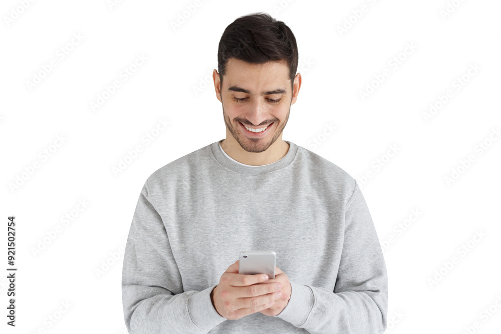 Young handsome guy standing, looking at screen of phone with smile Young handsome guy standing, looking at screen of phone with smile