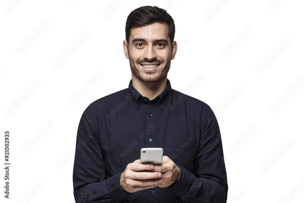Young business man standing isolated on grey background, looking at camera, holding phone with both hands Young business man standing isolated on grey background, looking at camera, holding phone with both hands