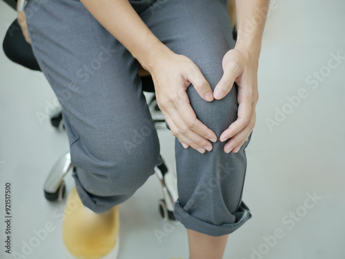 Business woman sits on a chair for a long time cause knee pain T photo