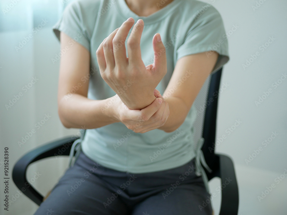 A young businesswoman suffered a wrist injury, numbness and pain from working too long. Health care and office syndrome concept. A young businesswoman suffered a wrist injury, numbness and pain from working too long. Health care and office syndrome concept.