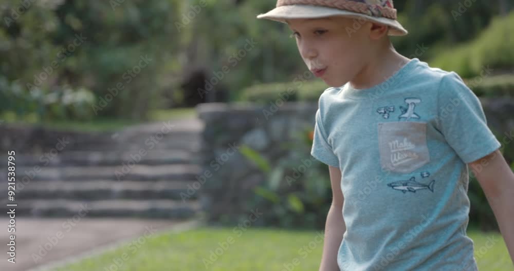 Boy throwing paper airplane up in air while playing at park - close up on face Boy throwing paper airplane up in air while playing at park - close up on face
