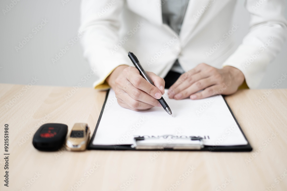 Car dealer businesswoman signing car insurance document or lease paper. Car insurance, loans and Car rentals concept Car dealer businesswoman signing car insurance document or lease paper. Car insurance, loans and Car rentals concept
