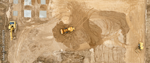 earthworks on building site by heavy construction machines to get the required ground level. aerial top view.