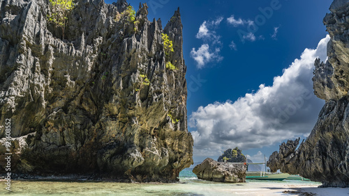 Fotografia Bizarre karst rocks near the ocean shore against a blue sky, clouds