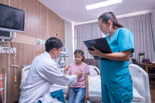 Photo of a doctor examining a little girl with a stethoscope in a clinic.