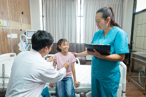 Photo of a doctor examining a little girl with a stethoscope in a clinic.