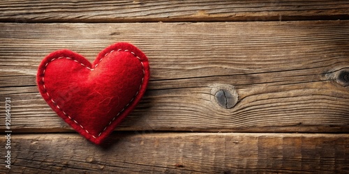 Vibrant red felt heart, handmade with precision, lies on a rustic wooden surface, offering ample space for text or designs, evoking warmth and affection.