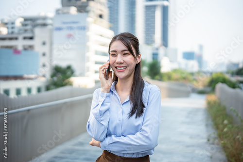 Asian young businesswoman talking on smartphone while walk in the city. 