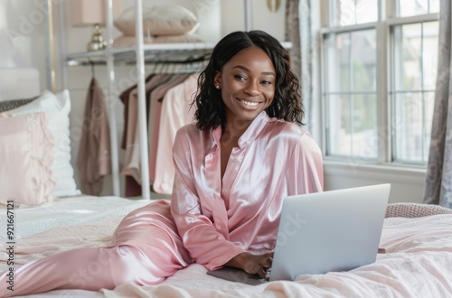 a black woman in pink pajamas sitting on the bed with a laptop, in a modern bedroom. Work from home, remote work, digital nomad concept Free Download a black woman in pink pajamas sitting on the bed with a laptop, in a modern bedroom. Work from home, remote work, digital nomad concept - GFXLoad