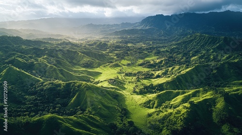 Overhead shot of a lush green valley nestled between mountain ridges with plenty of copy space in the sky