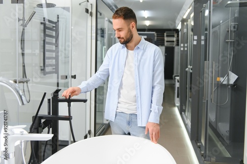 Young man choosing a bath and bath sink