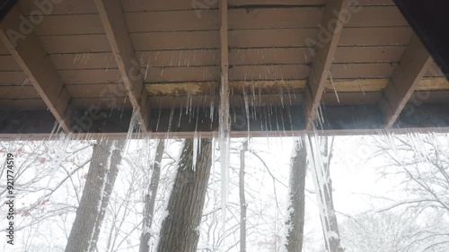 Zoom out on icicles hanging from a porch. Shot in 4k photo