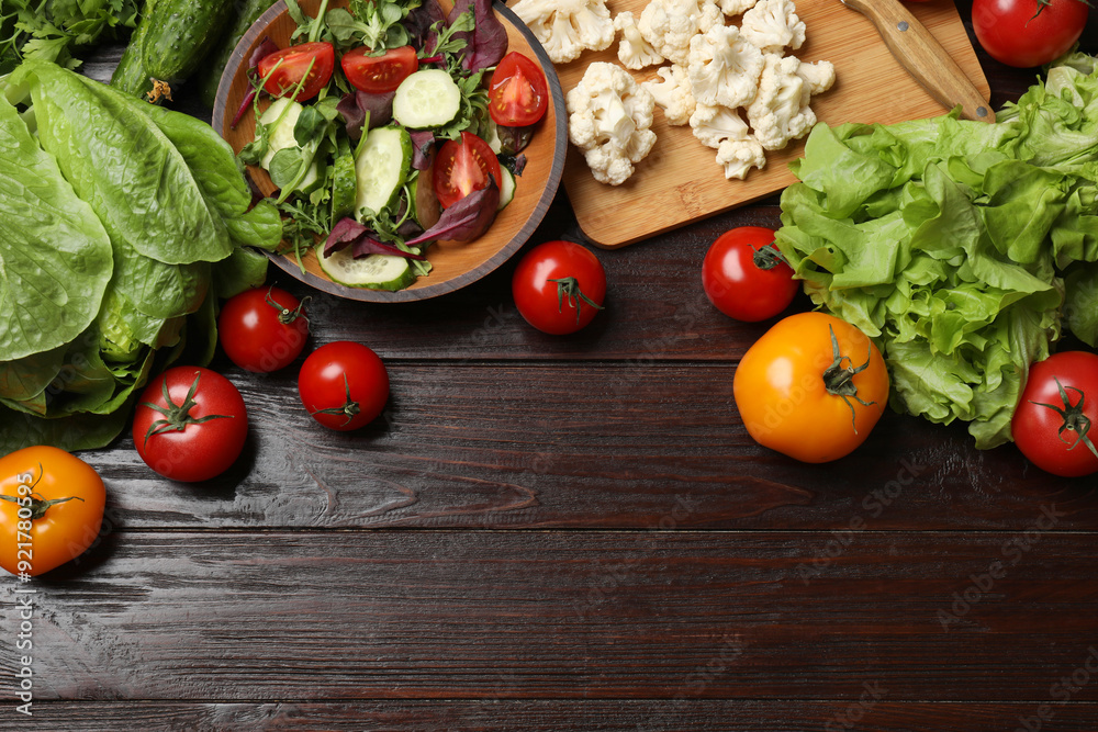 Healthy vegetarian food. Salad in bowl and vegetables on wooden table, flat lay. Space for text Healthy vegetarian food. Salad in bowl and vegetables on wooden table, flat lay. Space for text