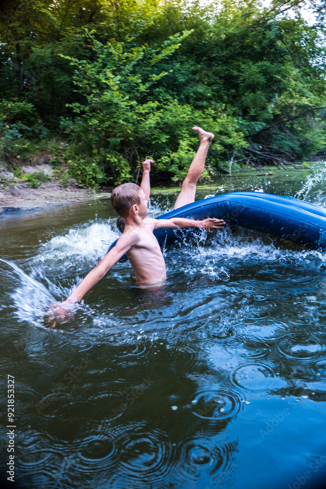 Fototapeta premium a boy bathes in a river in the summer on a hot day 