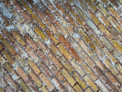 Close-up of an old brick wall in yellow and red tones with lots of texture.