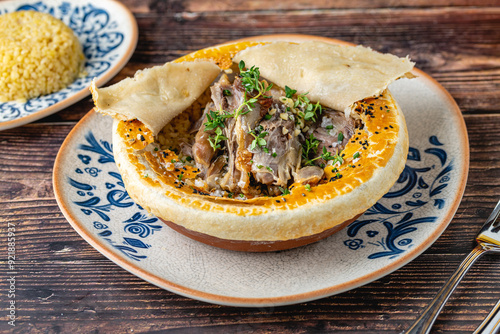 Lamb shank with bulgur pilaf and dough-covered top from traditional Turkish cuisine photo