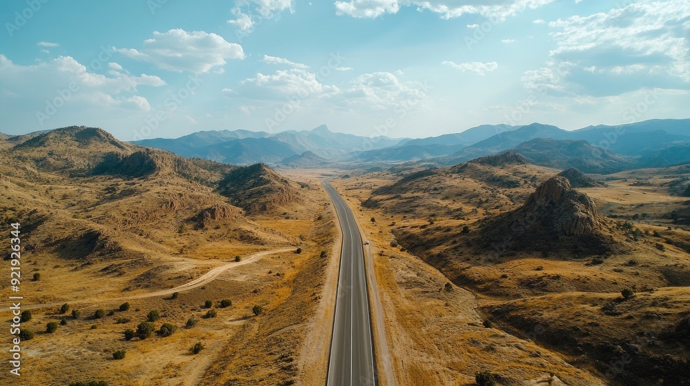 Aerial perspective of a long road leading through a mountain range with varying elevations. Perfect for journey and travel themes Aerial perspective of a long road leading through a mountain range with varying elevations. Perfect for journey and travel themes