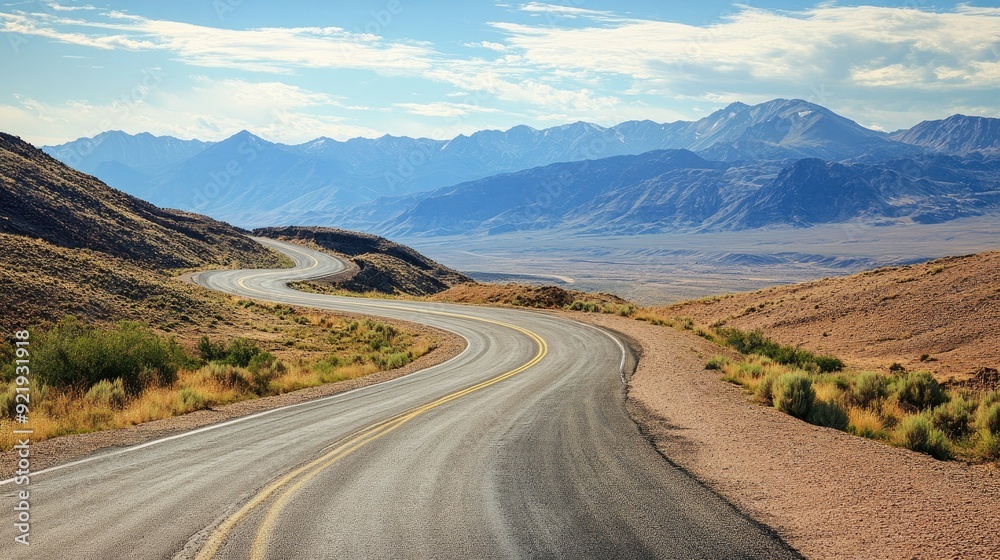 Scenic mountain road with sweeping curves and distant peaks surrounded by open space. Ideal for travel guides and exploration themes Scenic mountain road with sweeping curves and distant peaks surrounded by open space. Ideal for travel guides and exploration themes