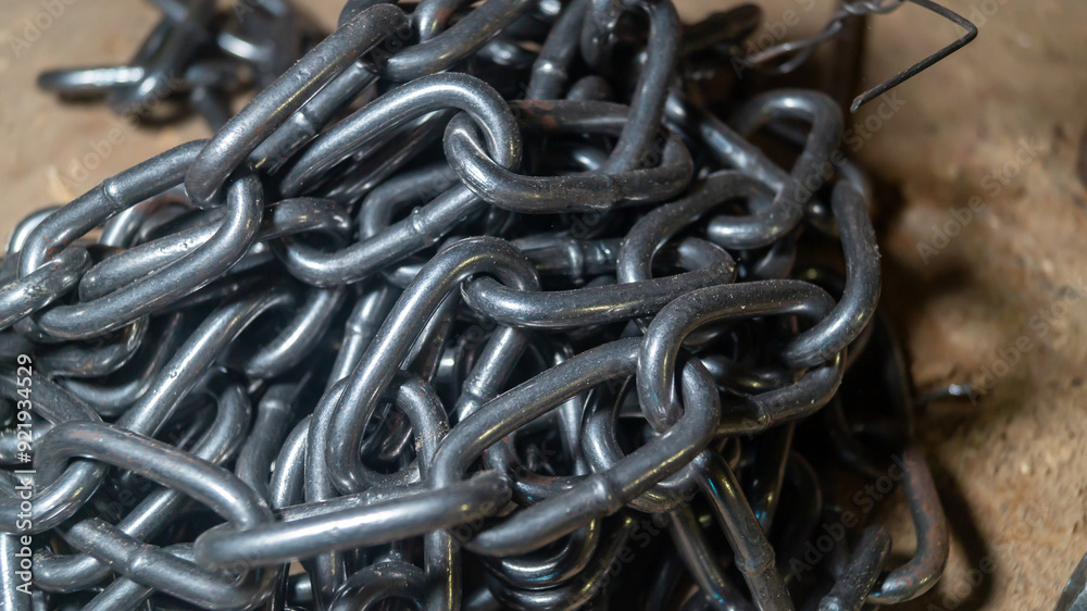 A close-up of the new large iron chain. The iron chain is stacked in a pile A close-up of the new large iron chain. The iron chain is stacked in a pile