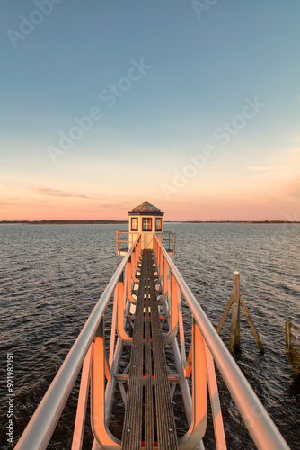 Sunset over Dutch national park Lauwersmeer in Friesland with an ancient lighthouse in front photo