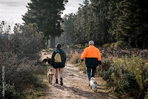 Canvas Print People walking dogs on a forest trail