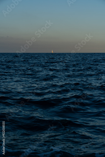 sunset over the sea and a tiny boat