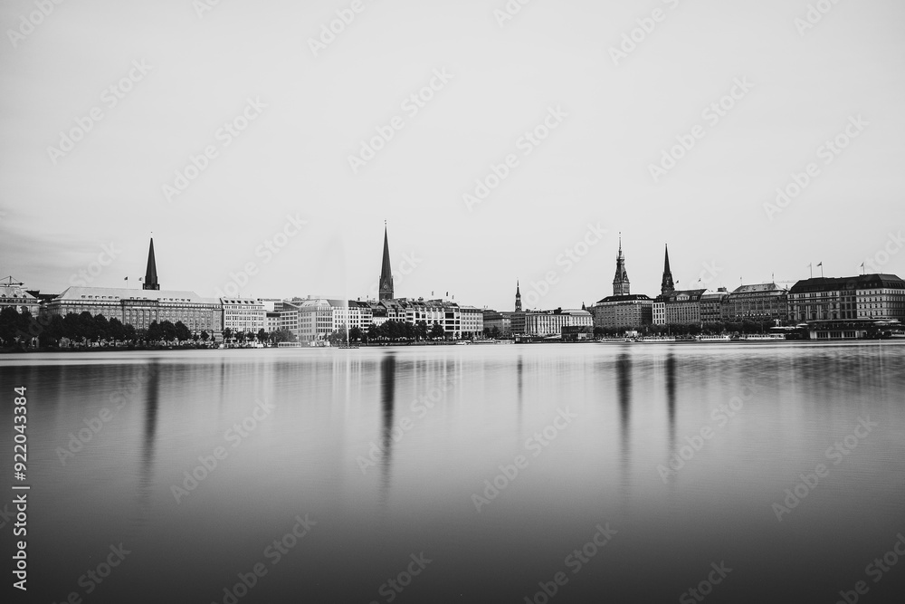 Fototapeta premium Reflection of the city onto a lake in Germany with the monochrome photo style near Hamburg, Germany