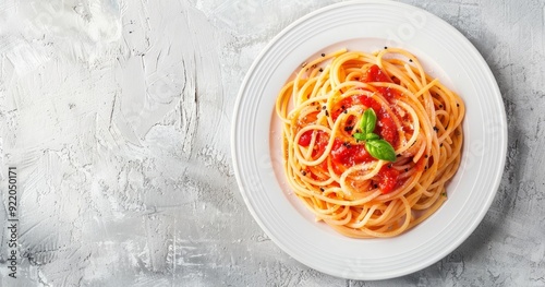 Photo of spaghetti with tomato sauce on a white plate, with a top view banner background leaving space for text or design, placed on a light gray concrete table. A concept food photography stoc photo