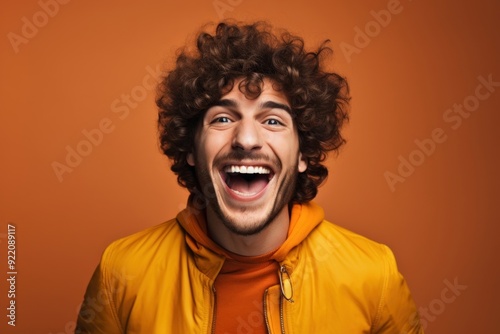 Excited curly haired man laughing shouting portrait.