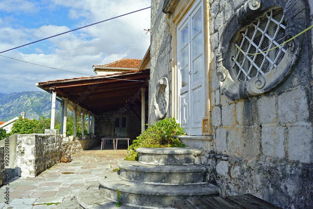 Fototapeta premium The courtyard of the Catholic Monastery of St. Anthony of Padua in Perast: a fragment of the Baroque church and the terrace behind it. Architectural landmarks in the Bay of Kotor, Montenegro.