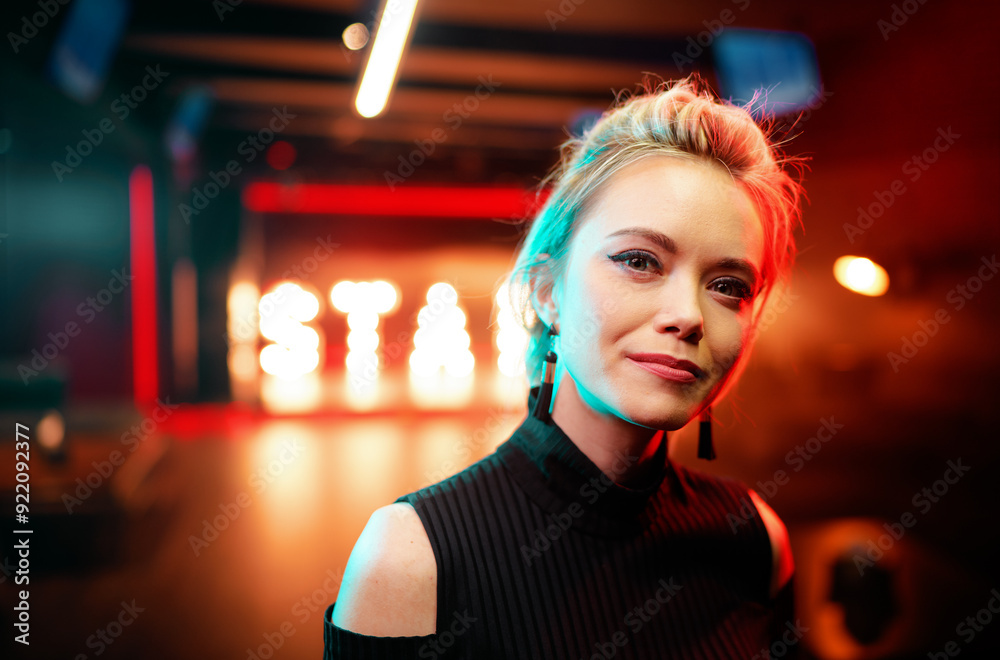 Portrait of young beautiful blonde woman posing in night club.