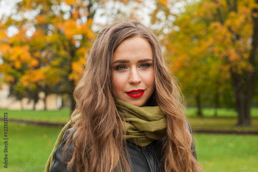 Naklejka premium Cute smiling autumn woman in fall park, outdoor portrait