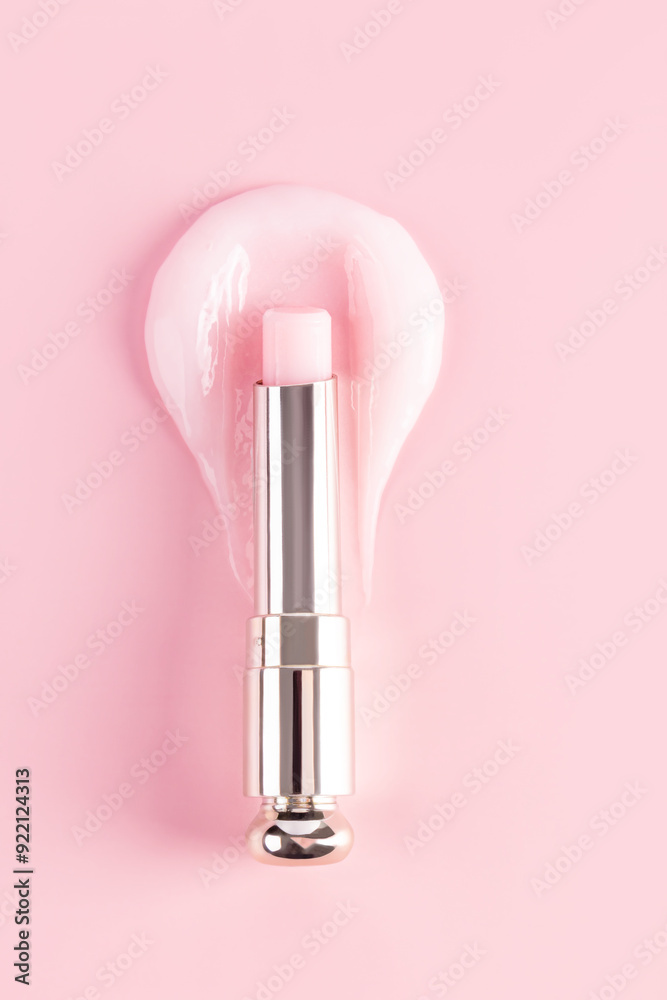 An open package of a tube of lip balm with a delicate structure to moisturize and nourish the lips lies on a sample of rose balm. vertical top view An open package of a tube of lip balm with a delicate structure to moisturize and nourish the lips lies on a sample of rose balm. vertical top view