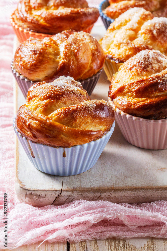 Rose-shaped yeast dough buns sprinkled with sugar in ceramic molds.